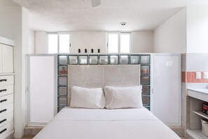 A bedroom with a bed, a wardrobe, and a glass-fronted cabinet with multiple compartments. - Fun & relax suite beside a park, 10 min to beaches (Cancún)