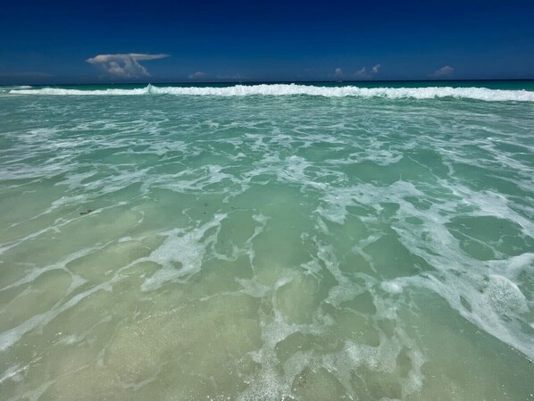 A clear view of ocean waves and a distant cloud formation.