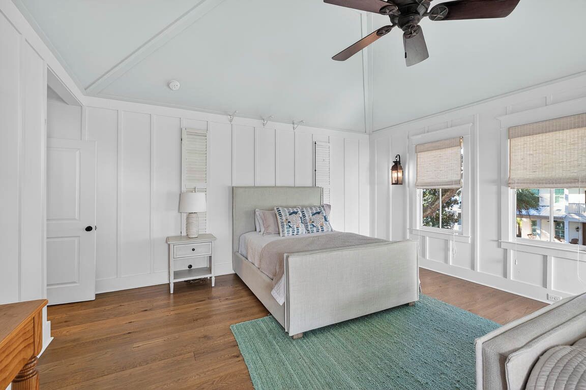 A bedroom with a bed, nightstand, and a ceiling fan.