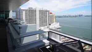 Un edificio alto con vistas a un cuerpo de agua y otros edificios al fondo.