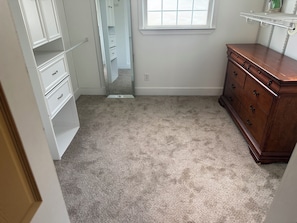 A room with a walk-in closet, a dresser, and a window. -     Relax & Unwind Stylish Decatur Home Near Downtown ATL (Decatur)