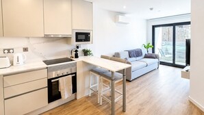 A modern kitchen with a dining area, a built-in oven, and a large window. - Dream retreat pool and gym (Gibraltar)