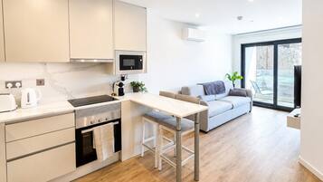 Una cocina moderna con zona de comedor, horno empotrado y un ventanal grande.