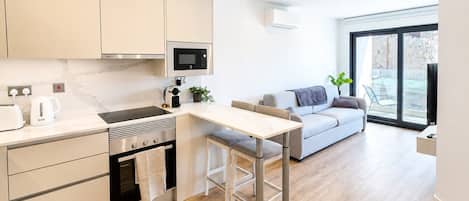 A modern kitchen with a dining area, a built-in oven, and a large window.