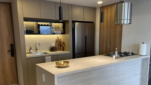A modern kitchen with a central island, stainless steel appliances, and wooden cabinetry.