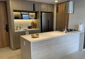 Eine moderne Küche mit Kochinsel, Edelstahlgeräten und Holzschränken.