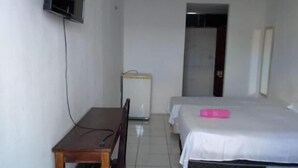 A hotel room with a desk, two beds, a television, and a refrigerator. - Center Hotel Picos (Picos)