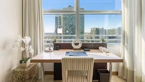 A modern office space with a large window, a desk, a chair, a ring light, and a potted plant. - ★ EXCLUSIVE Luxury Studio with FREE Parking ★ (Miami)