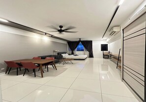 A modern living room with a dining area, a sofa, a TV, and a ceiling fan. - Studio Suites Near PWTC Kuala Lumpur,Malaysia (Wilayah Persekutuan)