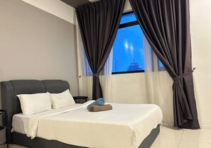 A bedroom with a bed, a window with curtains, a nightstand, and a view of a cityscape. - Studio Suites Near PWTC Kuala Lumpur,Malaysia (Wilayah Persekutuan)