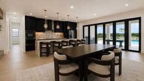 A modern kitchen with a large island, bar stools, and pendant lighting. - Luxury Miami 5BR Retreat W/Pool,Jacuzzi & Outdoor Kitchen . (Miami)