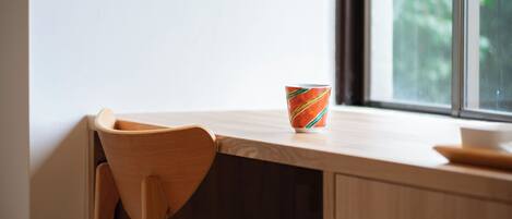 Una silla de madera y una mesa con una taza de colores.