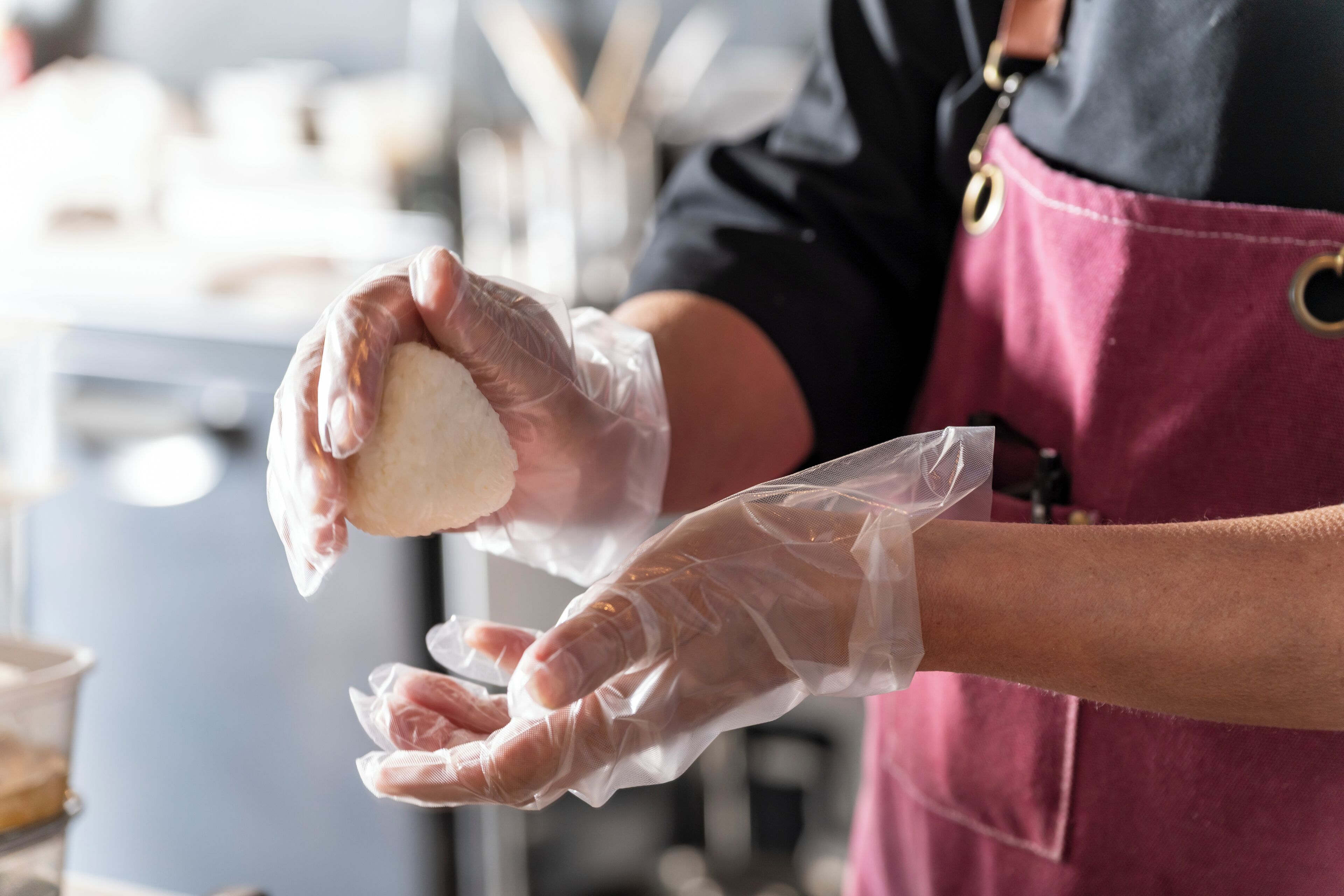 A person wearing gloves handling a food item.