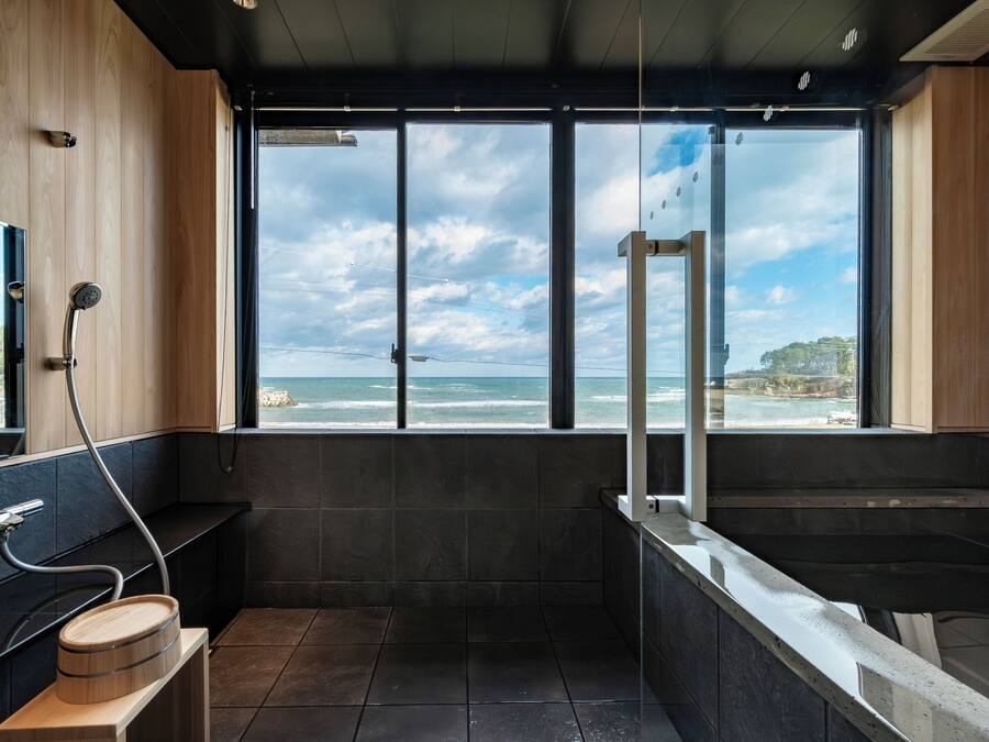 A modern bathroom with a large window, a shower, and a bathtub.