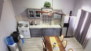 Eine kleine Küche mit Essbereich, Deckenventilator und Kühlschrank.