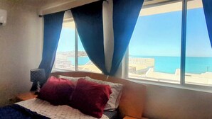 Ein Schlafzimmer mit Bett, Nachttisch und einem Fenster mit Vorhängen.