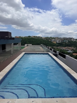 A rooftop swimming pool with a clear view of the surrounding buildings and landscape.