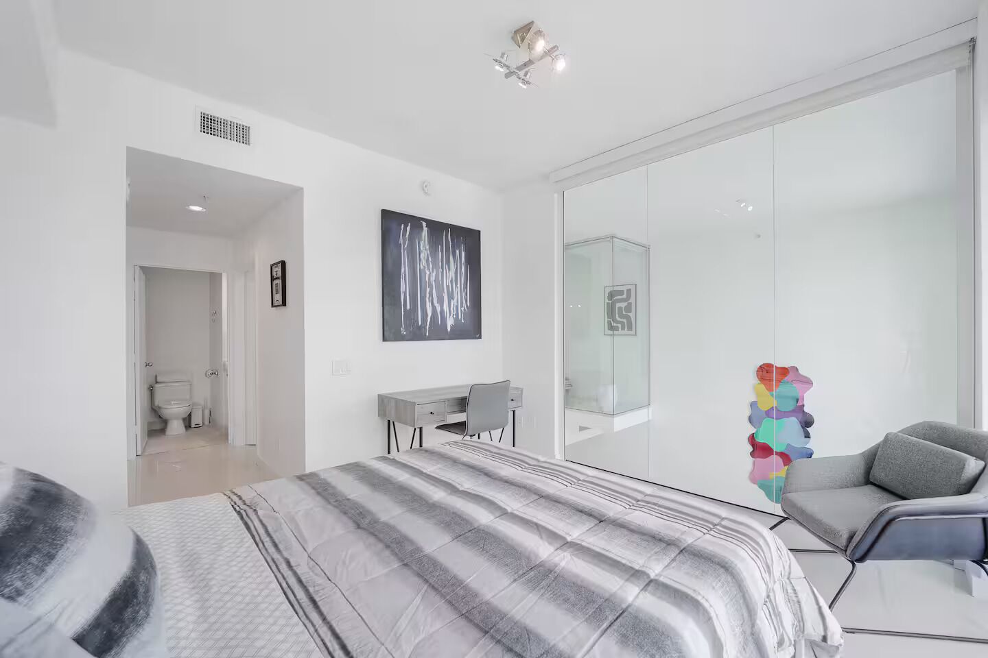 Une chambre à coucher moderne avec un lit, un bureau et une chaise.