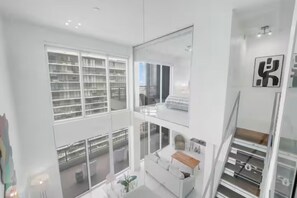 Ein modernes Interieur mit weißer Farbgebung, großen Fenstern und einer Schlafgalerie.