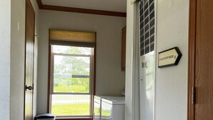 Ein Waschraum mit Fenster, Mülleimer und einem Schild mit Angaben zum Standort.