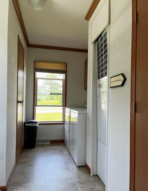Ein Waschraum mit Fenster, Mülleimer und einem Schild mit Angaben zum Standort.