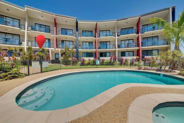 A multi-story hotel with a swimming pool, balconies, and a red heart-shaped decoration. - Sea Air Number Six On Queen (Yeppoon)