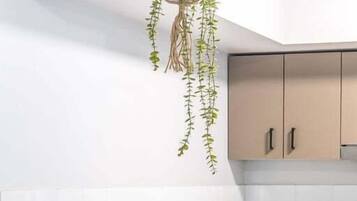 A kitchen with a hanging plant, a microwave, and cabinets.