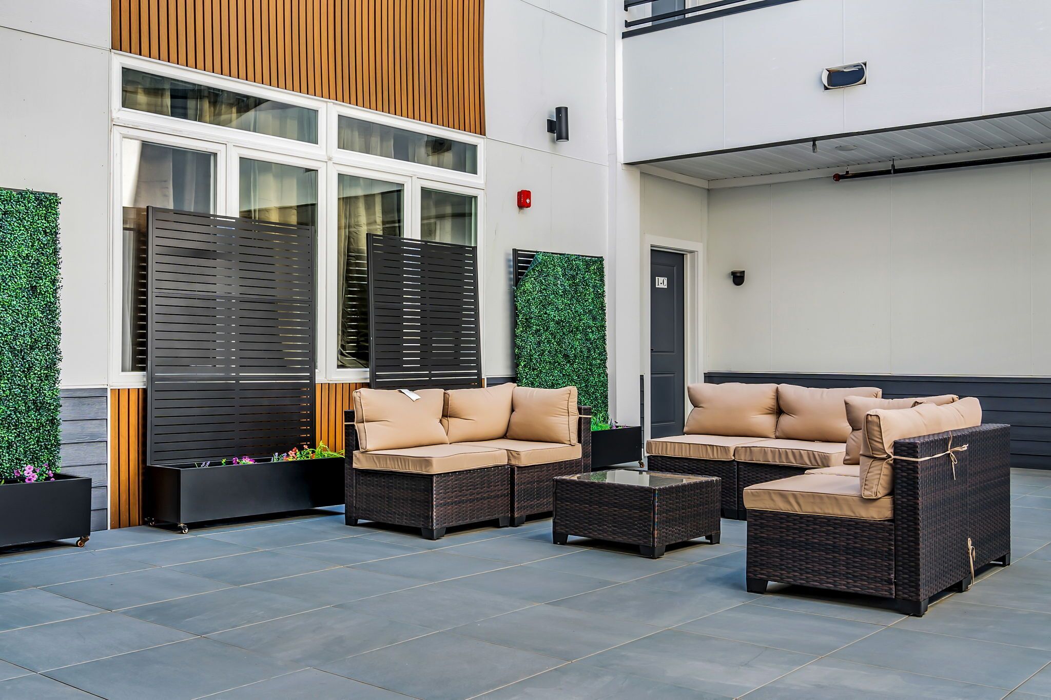 An outdoor seating area with wicker furniture and planters.