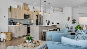 Una cocina moderna con armarios de madera, una isla central e iluminación colgante.