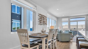 Un comedor con mesa, sillas y vistas al exterior.