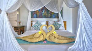 A bed with a canopy, a painting on the wall, and a decorative item resembling swans on the bed. - Villa Olala Penida (Penida Island)