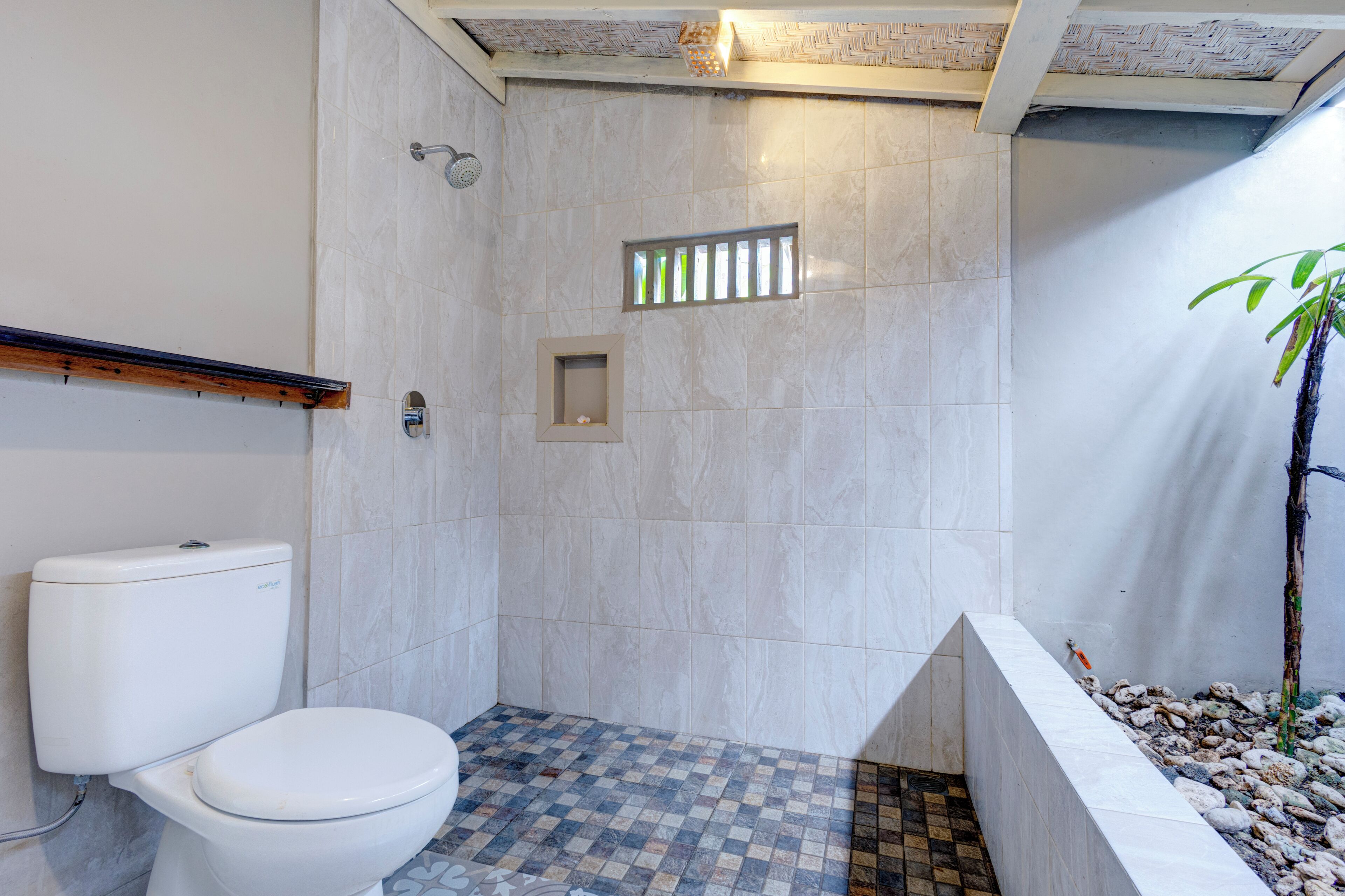 Ein Badezimmer mit Toilette, Dusche und einem Schachbrettmuster auf dem Boden.