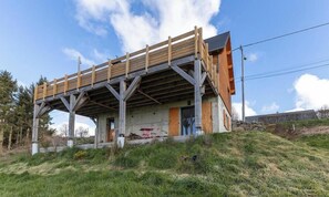 Ein modernes Gebäude mit einer Holzterrasse und einem Metallgerüst.