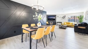 Un salon moderne comprenant un coin repas, un téléviseur à écran plat et une cheminée.