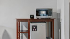 A microwave on a wooden table with a QR code and a sign.
