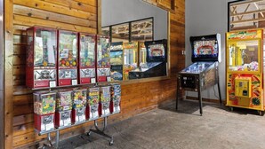 A row of arcade machines and claw machines in a wooden room. - Victorian Inn #107 | King Bed + Queen Sleeper Sofa (Elkhart Lake)