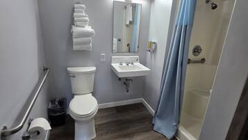 A bathroom with a toilet, sink, and shower.