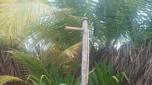 Eine rustikale Holzkonstruktion mit einem horizontalen Balken, umgeben von üppigem Grün.