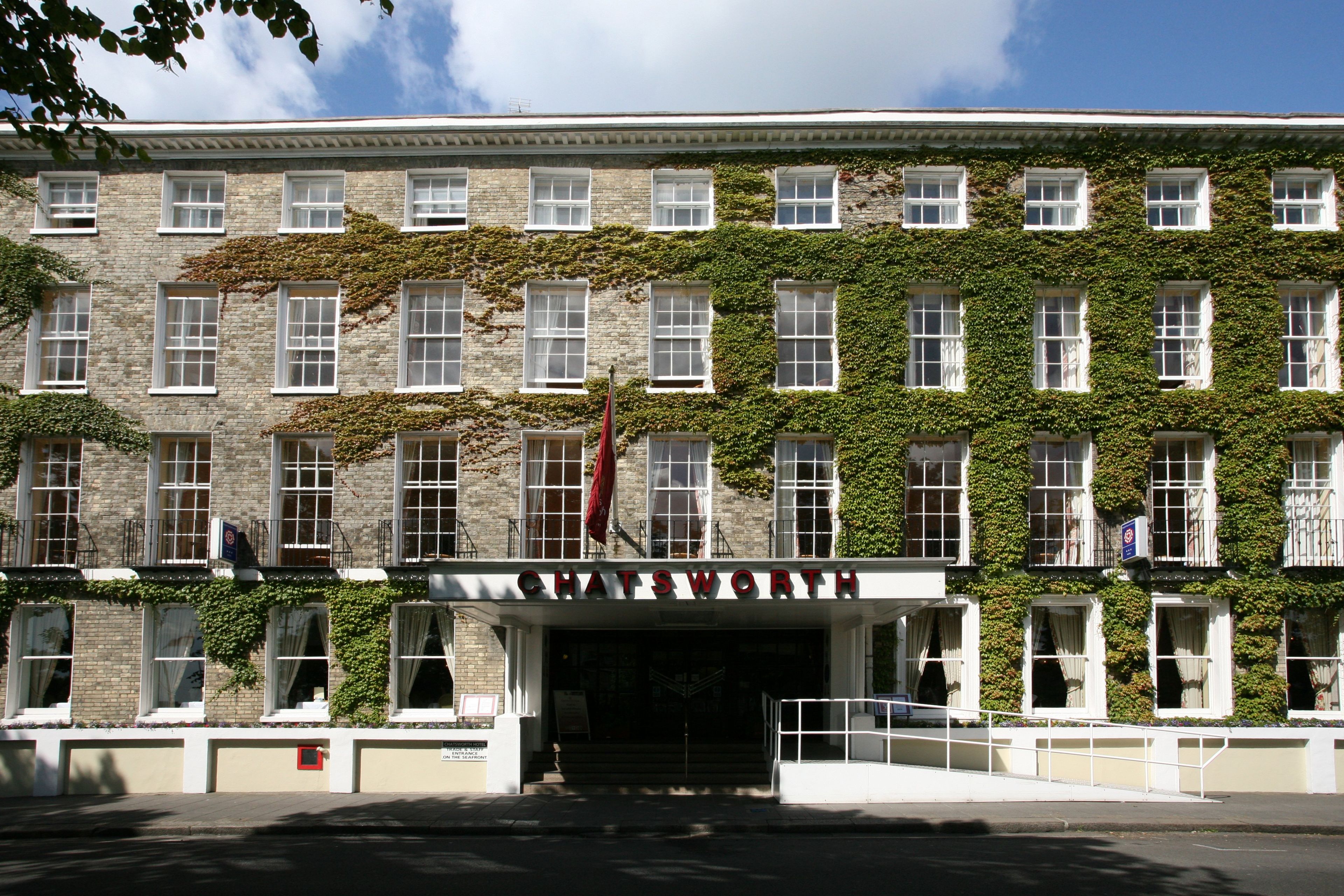 A building with a sign reading 'CHATSWORTH HOTEL' and a flag.