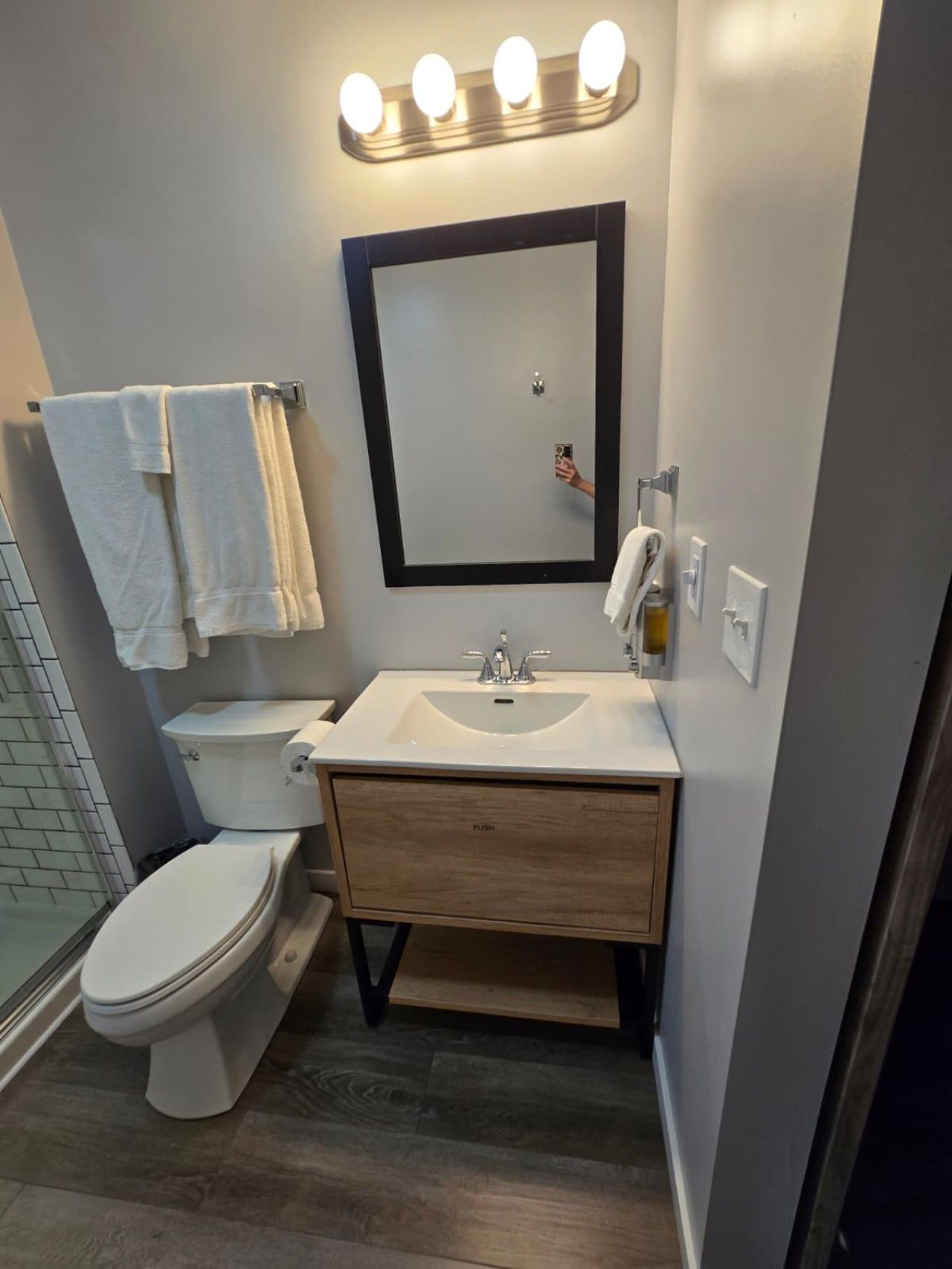 Une salle de bain moderne avec des toilettes, un lavabo et un miroir.