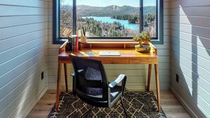 A corner room with a desk, chair, and a large window offering a view of a lake and forest. - 3-BEDROOM, 3-BATH ARCHITECTURAL MARVEL IN LAKE ARROWHEAD (Lake Arrowhead)