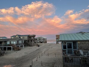A beachside property with wooden structures, a sandy beach, and a view of the ocean.