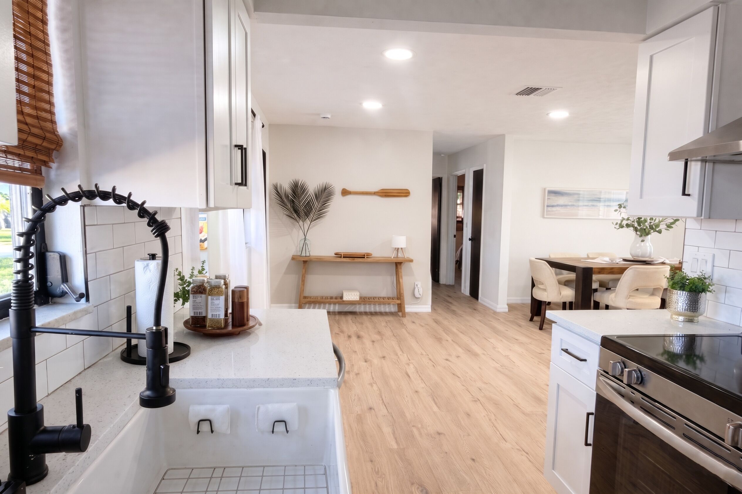 Una cocina moderna con encimera de madera, horno empotrado y comedor con mesa y sillas.