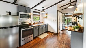 Una cocina moderna con electrodomésticos de acero inoxidable, piso de madera y vistas al exterior.