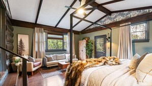 Un dormitorio con una cama con dosel, un sofá, un armario y una escalera.