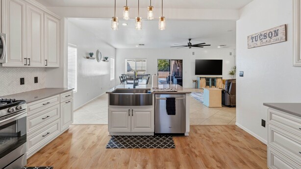 A modern kitchen with white cabinets, a stainless steel sink, and a built-in oven. - Luxury Private Pool & Spa Home | Resort Backyard | Sleeps 10 (Tucson)