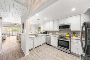 A modern kitchen with white cabinetry, a stainless steel refrigerator, and a built-in oven. - 🦩Book Me Baby! Coastal Krewe in Miramar Beach🦩 (Miramar Beach)