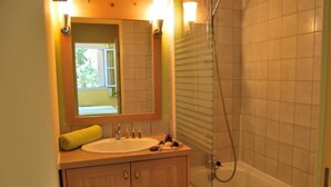 Ein Badezimmer mit Waschbecken, Spiegel und Dusche.