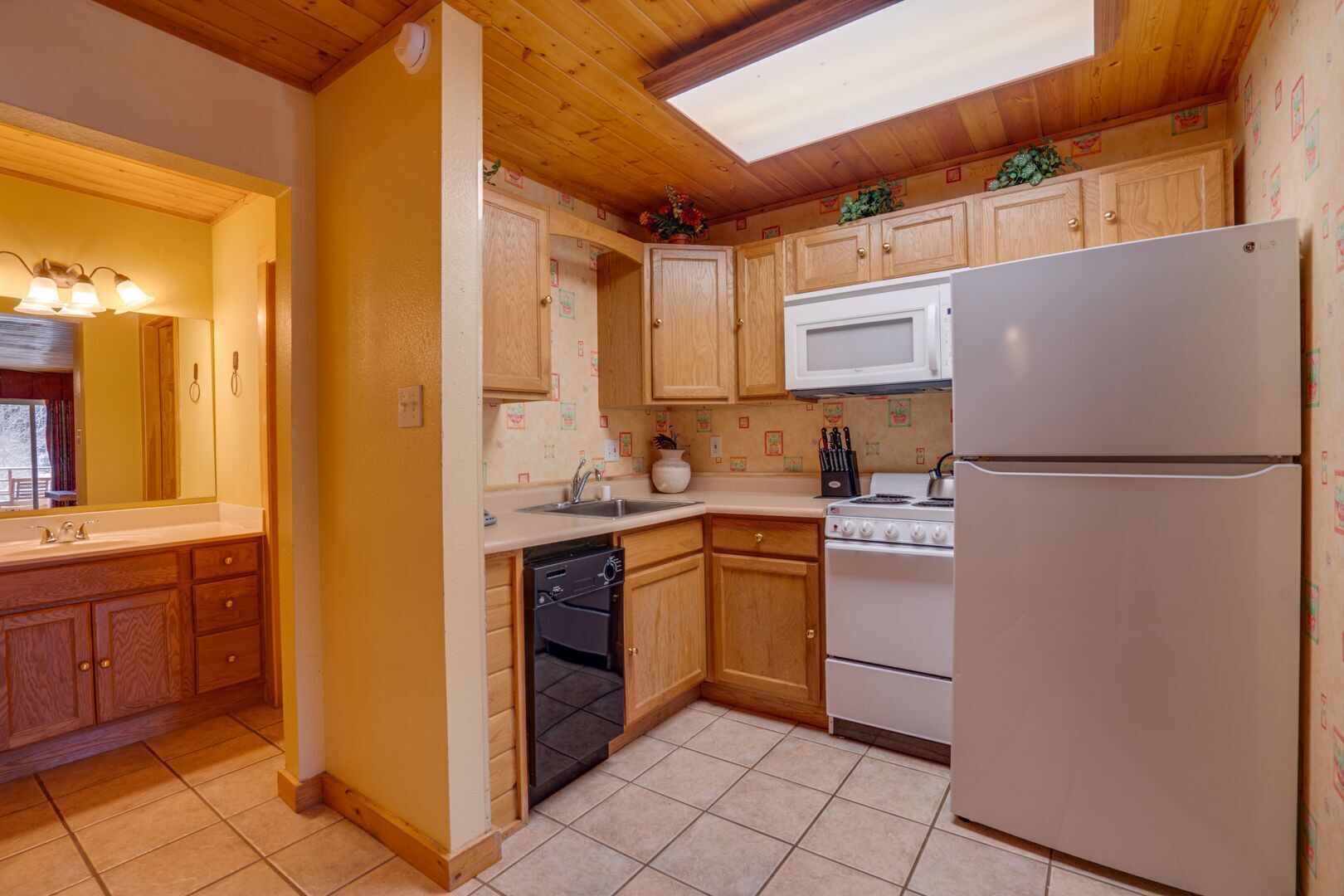 A kitchen with wooden cabinets, a white refrigerator, a stove, and a dishwasher.