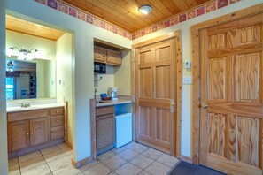 A compact kitchen with wooden cabinets, a microwave, and a coffee maker. - Suite at the Eagle Wing of the Lodge at Angel Fire Resort (Angel Fire)